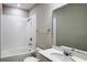 Cozy bathroom features white tile, standard tub-shower combo, and a white vanity with sink at 9917 Summerlake Groves St, Winter Garden, FL 34787