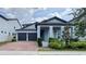 Charming two-story home featuring a brick driveway, lush landscaping, and a covered entryway with elegant columns at 9917 Summerlake Groves St, Winter Garden, FL 34787