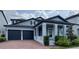Charming two-story home featuring a brick driveway, lush landscaping, and a covered entryway with elegant columns at 9917 Summerlake Groves St, Winter Garden, FL 34787