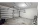 Spacious two-car garage features ample parking with white painted walls and concrete flooring at 9917 Summerlake Groves St, Winter Garden, FL 34787