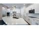 An open kitchen with white cabinets, stainless steel appliances and a spacious quartz countertop at 9917 Summerlake Groves St, Winter Garden, FL 34787