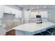 A well-lit open kitchen with white cabinetry, a quartz countertop, and a black faucet at 9917 Summerlake Groves St, Winter Garden, FL 34787