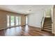 Open living room boasts wood floors, large glass doors to the pool, and staircase access at 9917 Summerlake Groves St, Winter Garden, FL 34787