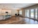 Bright open-concept living space features hardwood floors, a kitchen island, dining area, and patio doors at 9917 Summerlake Groves St, Winter Garden, FL 34787