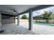 Covered patio area featuring an outdoor fan and a serene view of the backyard and the swimming pool at 9917 Summerlake Groves St, Winter Garden, FL 34787