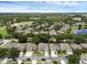 Aerial view showcases a neighborhood near a golf course, with lush landscaping and a serene lake at 10125 Sandy Marsh Ln, Orlando, FL 32832