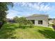 Expansive backyard with lush green grass, a screened-in porch, and views of the pool area, ideal for relaxing at 10125 Sandy Marsh Ln, Orlando, FL 32832