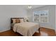 Well-lit bedroom with hardwood floors, neutral bedding, and a ceiling fan at 10125 Sandy Marsh Ln, Orlando, FL 32832