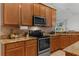 Gourmet kitchen featuring granite countertops, stainless steel appliances, and wood cabinets at 10125 Sandy Marsh Ln, Orlando, FL 32832