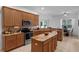 Well-lit kitchen with stainless appliances, granite counters, and center island with breakfast bar at 10125 Sandy Marsh Ln, Orlando, FL 32832