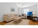 Welcoming living room featuring a comfortable sofa, armchair, and a television for entertainment at 10125 Sandy Marsh Ln, Orlando, FL 32832