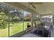 Screened-in patio offers an outdoor dining space with lush backyard views and a ceiling fan at 10125 Sandy Marsh Ln, Orlando, FL 32832