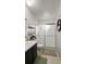 This bathroom has a white toilet and sink with a frosted glass shower and floating shelves at 10169 Matchlock Dr, Orlando, FL 32821