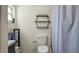 The bathroom features a white toilet, hexagonal shelving, and a shower behind a gray curtain at 10169 Matchlock Dr, Orlando, FL 32821