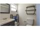 This bathroom features a white toilet and sink with dark wood cabinets and hexagonal shelving at 10169 Matchlock Dr, Orlando, FL 32821