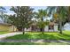 Inviting single-story home with red tile roof, offering curb appeal with its lush lawn and mature trees at 10169 Matchlock Dr, Orlando, FL 32821