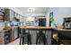 Well-lit kitchen featuring modern gray cabinetry, a breakfast bar, and black appliances at 10169 Matchlock Dr, Orlando, FL 32821
