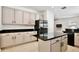 Charming kitchen with an island, stainless steel refrigerator, and modern light fixtures at 1034 Alvina Ln, Oviedo, FL 32765
