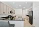 Well-lit kitchen with black countertops, white cabinets, and modern appliances at 1034 Alvina Ln, Oviedo, FL 32765