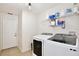 Bright laundry room featuring a modern washer and dryer, overhead lighting, and storage shelves at 1034 Alvina Ln, Oviedo, FL 32765