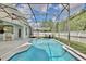 Sparkling pool with screened enclosure, patio seating, and umbrella for shade at 1034 Alvina Ln, Oviedo, FL 32765