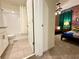 Hallway view of a bathroom with tiled floors, a vanity, and a bath tub at 1077 Leader St, Davenport, FL 33896