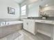 Bright bathroom with a soaking tub, vanity, modern fixtures, and ceramic tile flooring at 1077 Leader St, Davenport, FL 33896