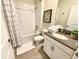 Clean bathroom with a shower-tub combo, a decorative shower curtain and a vanity with a gray countertop at 1077 Leader St, Davenport, FL 33896