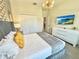 Bright bedroom with a TV, dresser, closet, and a comfortable king-sized bed with gold pillows at 1077 Leader St, Davenport, FL 33896