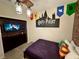 Themed bedroom with a twin bed, a mounted TV, and cozy lighting at 1077 Leader St, Davenport, FL 33896