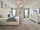 Spacious bedroom with a chandelier, carpeted floor, and natural light from two windows at 1077 Leader St, Davenport, FL 33896