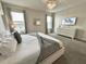 This bedroom features a modern chandelier, gray and white decor at 1077 Leader St, Davenport, FL 33896