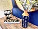 Charming decor with a wooden table holding nautical-themed vase, lamp, and 'Welcome to our home' sign at 1077 Leader St, Davenport, FL 33896