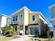Modern two-story home featuring a mint-green garage door, complemented by small palm trees and fresh landscaping at 1077 Leader St, Davenport, FL 33896