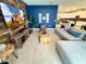 Open-concept living room with TV, stylish wood accent wall, plush sectional sofa, and ample natural light at 1077 Leader St, Davenport, FL 33896