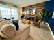 Open-concept living room with a comfortable sectional sofa, stylish decor, and sliding glass doors to the backyard at 1077 Leader St, Davenport, FL 33896