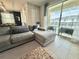 Bright living room with sectional sofa and sliding glass doors that open to a view of the pool at 1077 Leader St, Davenport, FL 33896