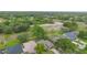 Aerial shot of a home nestled in a lush, green neighborhood with a nearby open field at 11 Huntley Ct, Haines City, FL 33844