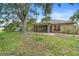 Inviting backyard with a screened lanai, beautiful landscaping, and mature trees for outdoor relaxation at 11 Huntley Ct, Haines City, FL 33844