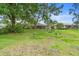Serene backyard featuring mature trees and lush lawn, creating a private and peaceful outdoor oasis at 11 Huntley Ct, Haines City, FL 33844