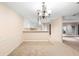 Spacious dining room with classic chandelier and adjacent kitchen and entry for seamless living at 11 Huntley Ct, Haines City, FL 33844