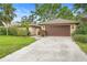 Spacious home featuring an attached garage, lush lawn, and beautiful landscaping at 11 Huntley Ct, Haines City, FL 33844