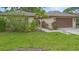 Charming single-story home with a well-manicured lawn, mature landscaping, and an attached two-car garage at 11 Huntley Ct, Haines City, FL 33844