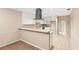 Open concept kitchen with white cabinets, stainless steel hood, and breakfast bar at 11 Huntley Ct, Haines City, FL 33844
