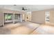 Spacious living room with neutral carpet, tile floor transition, and screened lanai access at 11 Huntley Ct, Haines City, FL 33844