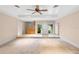 Open living room with neutral carpet, a ceiling fan, and natural light from large windows at 11 Huntley Ct, Haines City, FL 33844