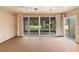 Screened patio with expansive sliding doors, ceiling fan, neutral flooring, and backyard views at 11 Huntley Ct, Haines City, FL 33844