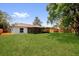Expansive backyard featuring lush lawn, a screened patio and a classic wooden fence at 1301 Paradise Ln, Winter Park, FL 32792
