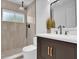 Modern bathroom featuring a tiled shower, a window, and a stylish sink with gold accents at 1301 Paradise Ln, Winter Park, FL 32792