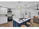 Bright and modern kitchen with a blue island, stainless steel appliances, and stylish pendant lighting at 1301 Paradise Ln, Winter Park, FL 32792